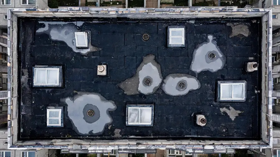Dach płaski bloku z góry: wpusty, świetliki, zastoiny po deszczu