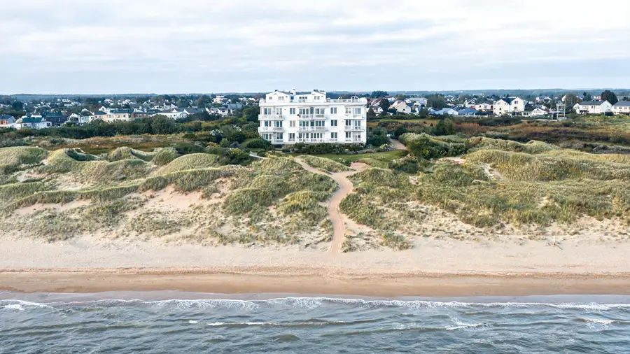 Apartamentowiec, ścieżka przez wydmy i plaża w jednym kadrze: ujęcie „odległość do morza"